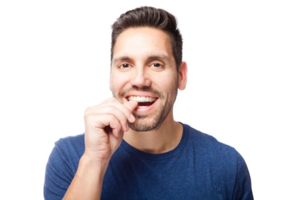 guy smiling with hands on teeth
