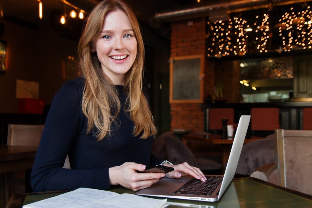 woman smiling while using a laptop
